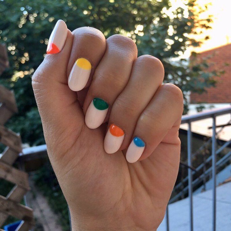 Manicure neutra com design de sem i-lua com várias coloridas de unhas