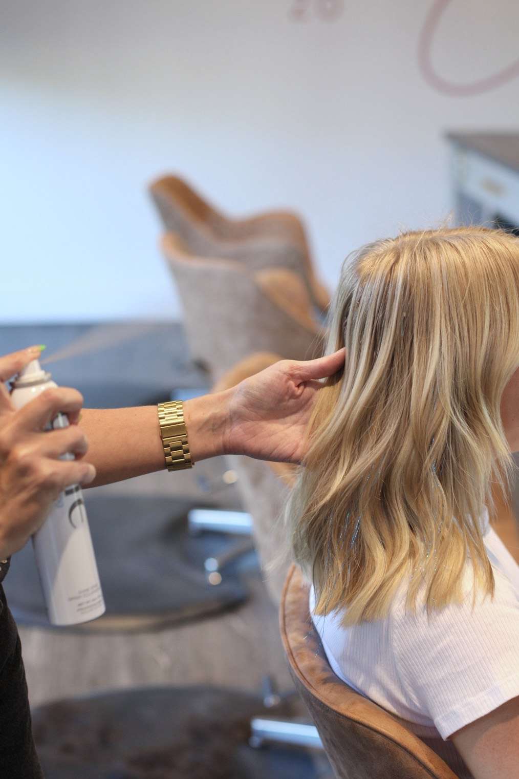 Jessica Page aplica uma ferramenta de proteção térmica ao cabelo do cliente