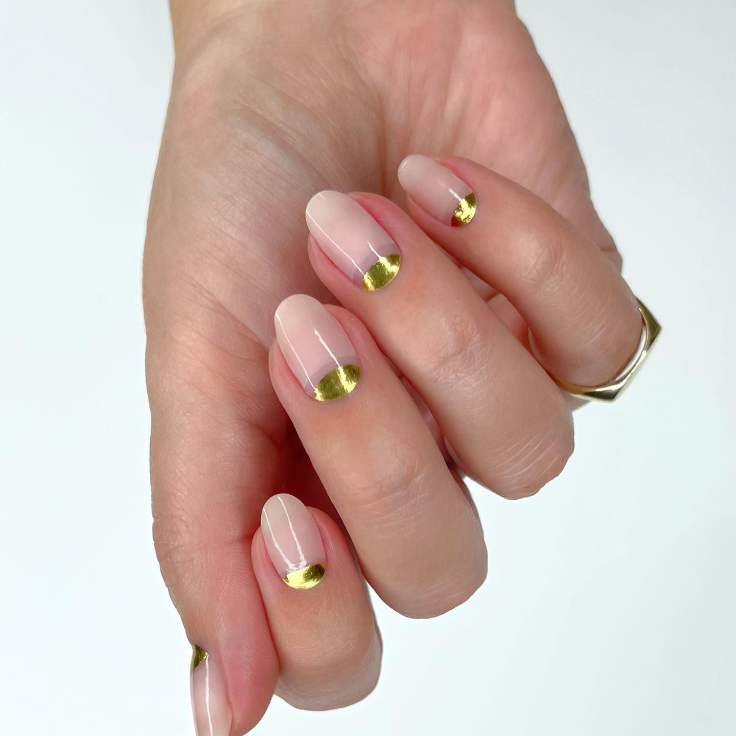 Manicure de verniz dourado na cutícula e um design de sem i-lua