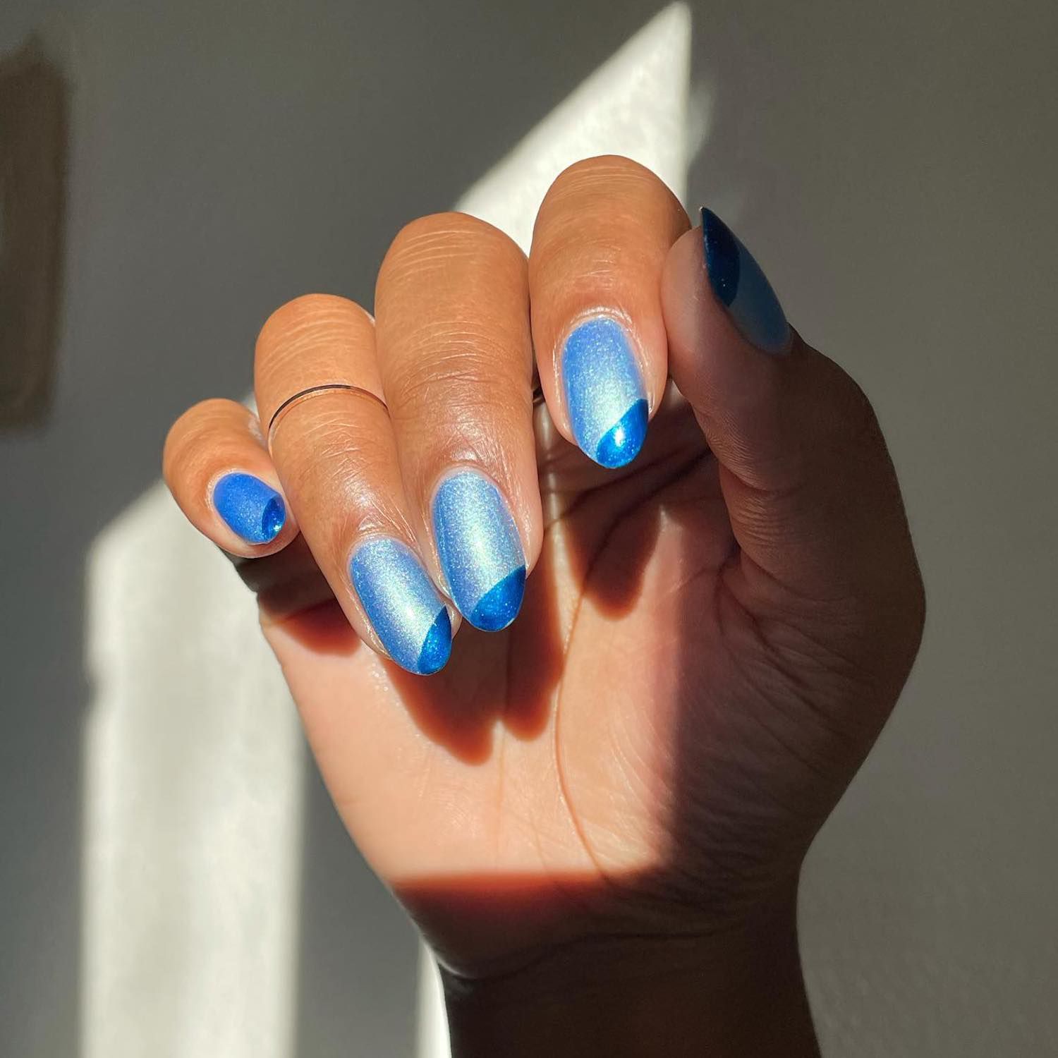 Unhas metálicas azuis claras com pontas diagonais metálicas azuis escuras