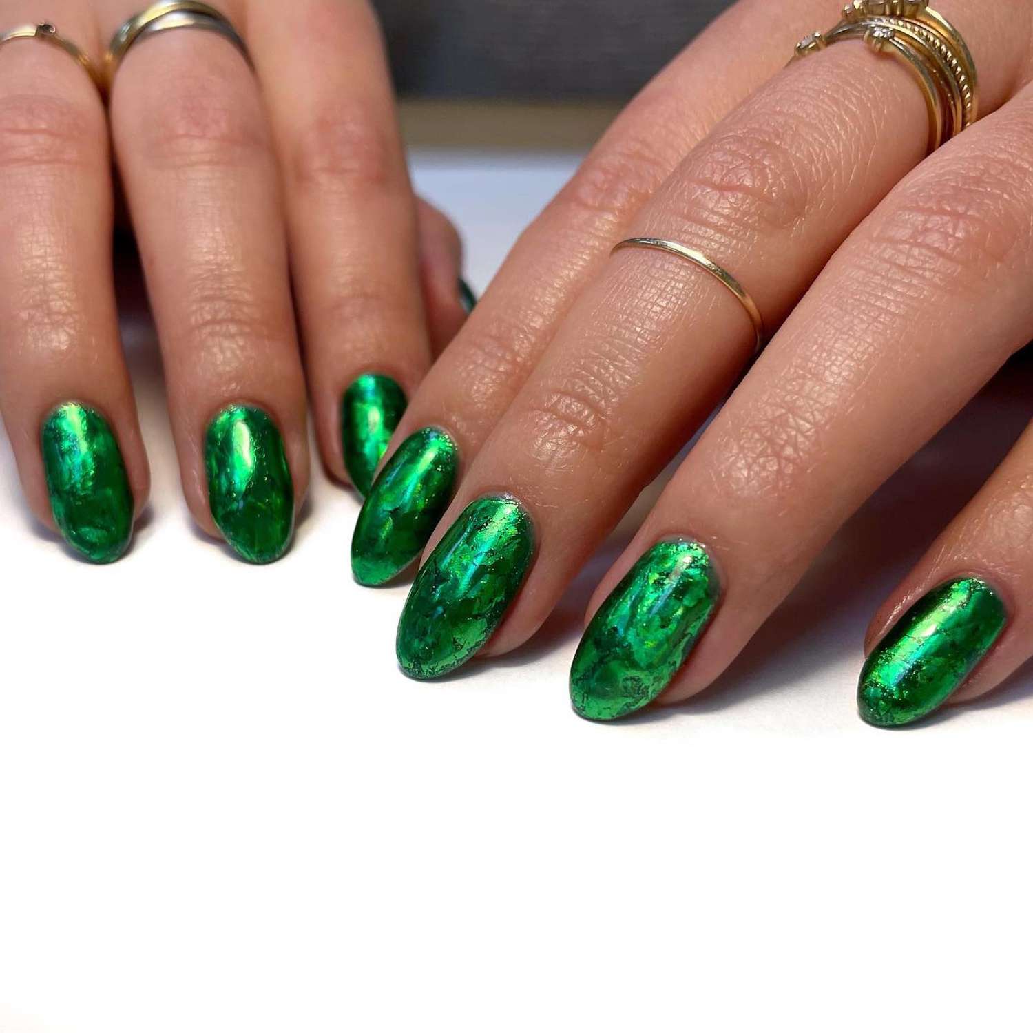 O close de uma manicure verde brilhante e levemente de mármore