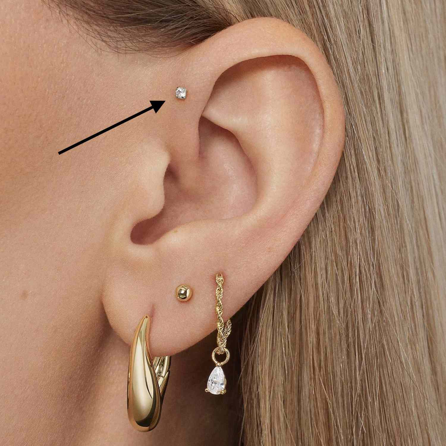 close de uma loira com um piercing no lóbulo da orelha
