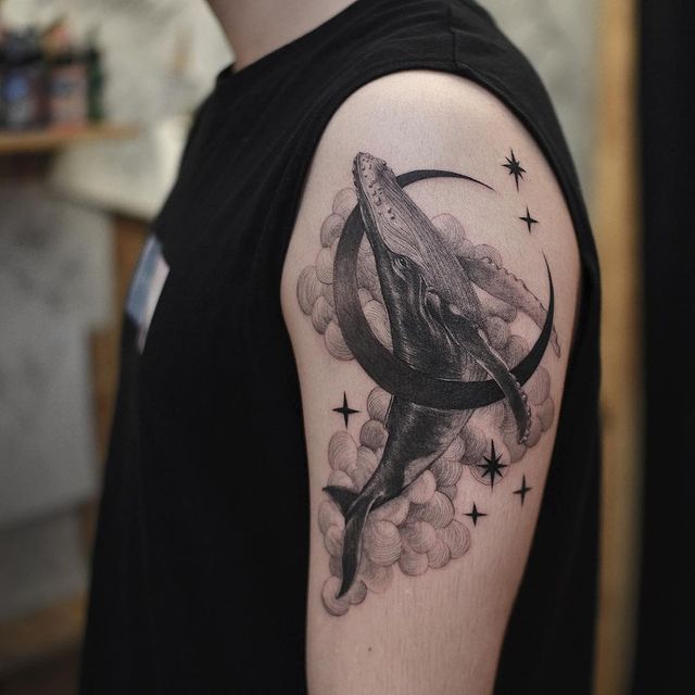 Baleia azul dentro de uma tatuagem crescente com nuvens e estrelas