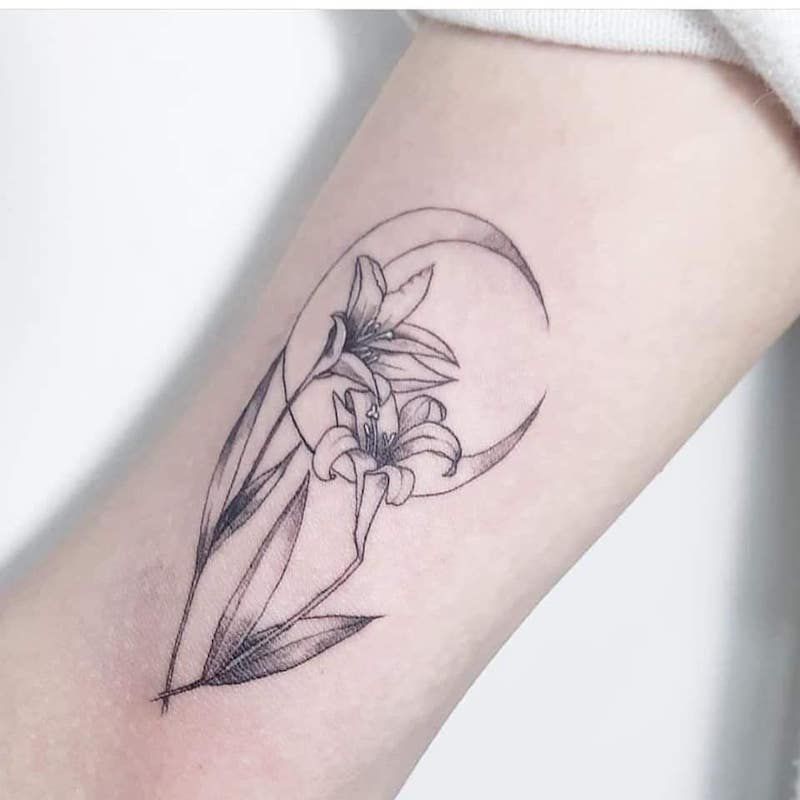 Flores de lírio de tatuagem de lua crescente