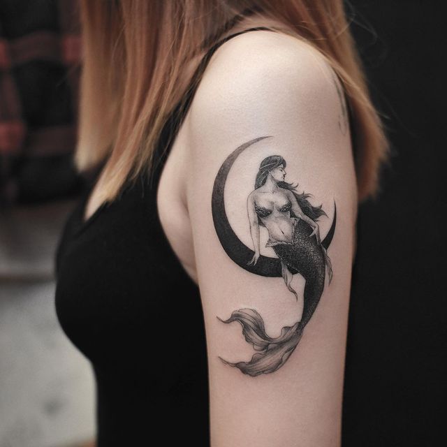 sereia sentada em tatuagem de lua crescente