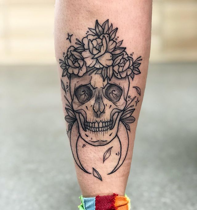 Crânio de tatuagem com flores e crescente