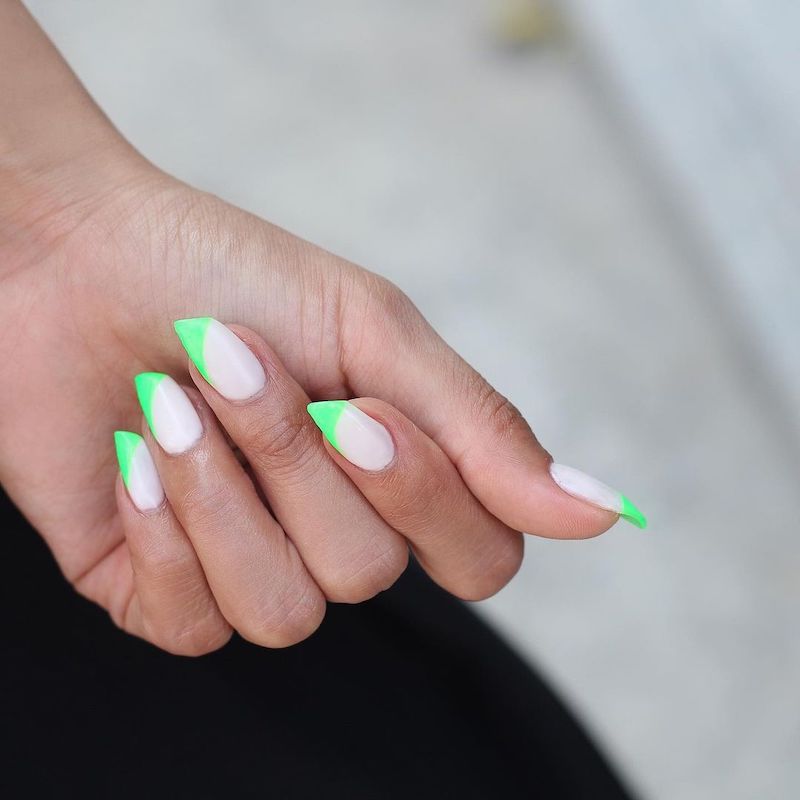 Lipstick unhas com uma base branca e dicas verde-neon