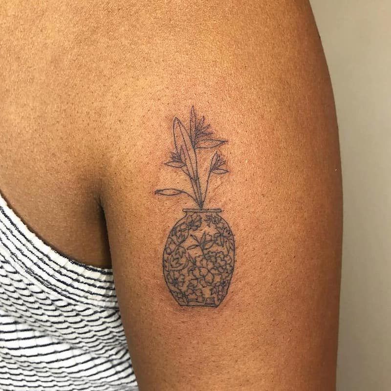 Tatuagens na mão de um vaso e flor