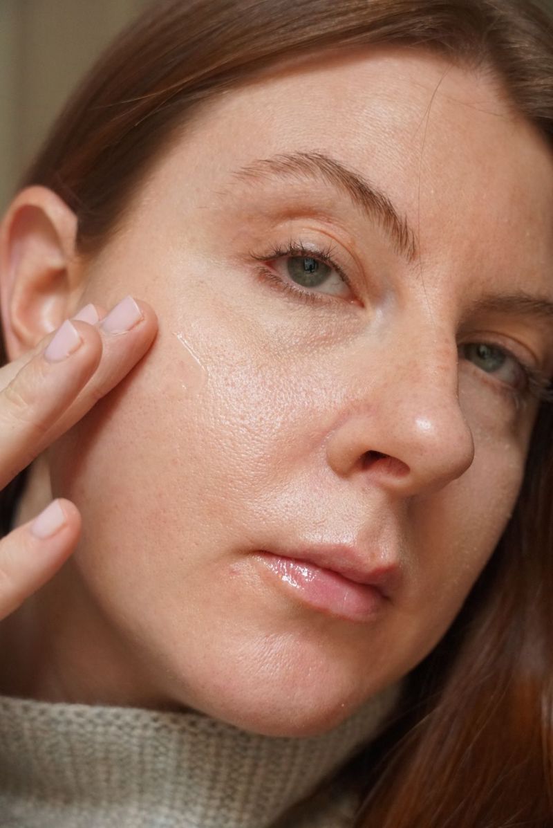 Uma mulher aplica uma cartilha à pele