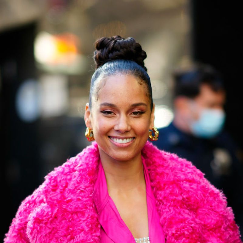 Alicia Keys com coque alto e casaco rosa fofo