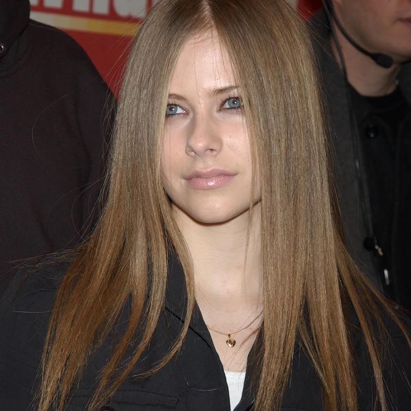 Avril Lavin com longos cabelos retos marrom-cogumelos e maquiagem mínima