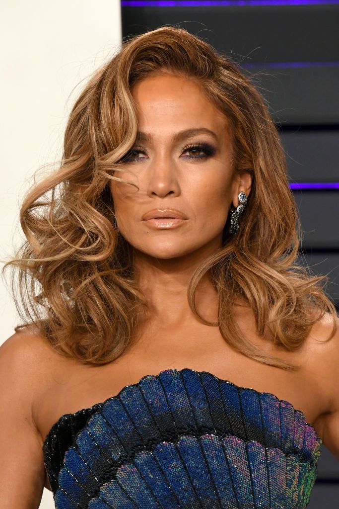 Jennifer Lopez com cabelo cacheado de comprimento médio