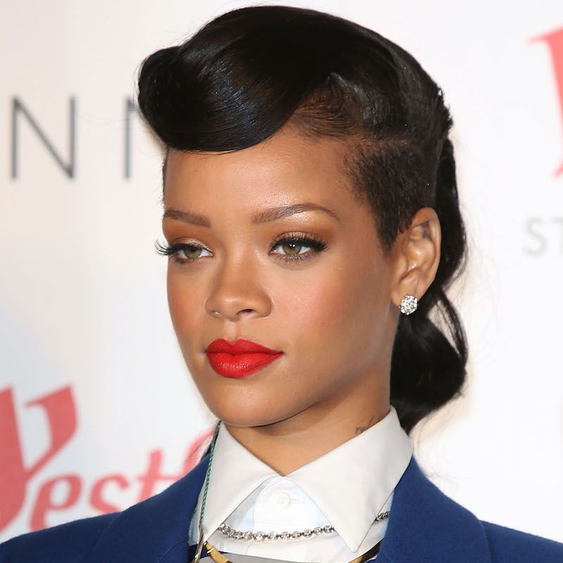 Rihanna com penteado estilo anos 50, lado raspado e batom vermelho