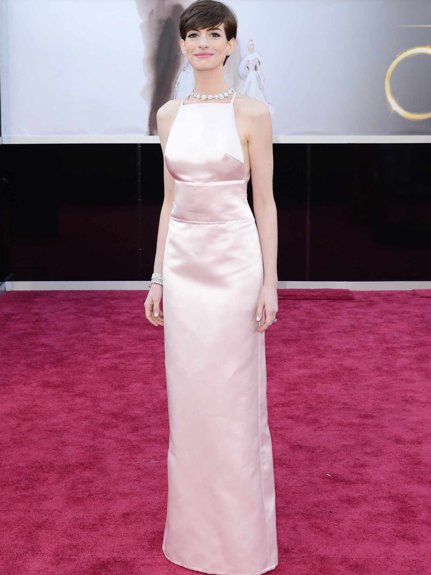 Anne Hathaway usa vestido Prada rosa claro e joias brilhantes no Oscar 2013