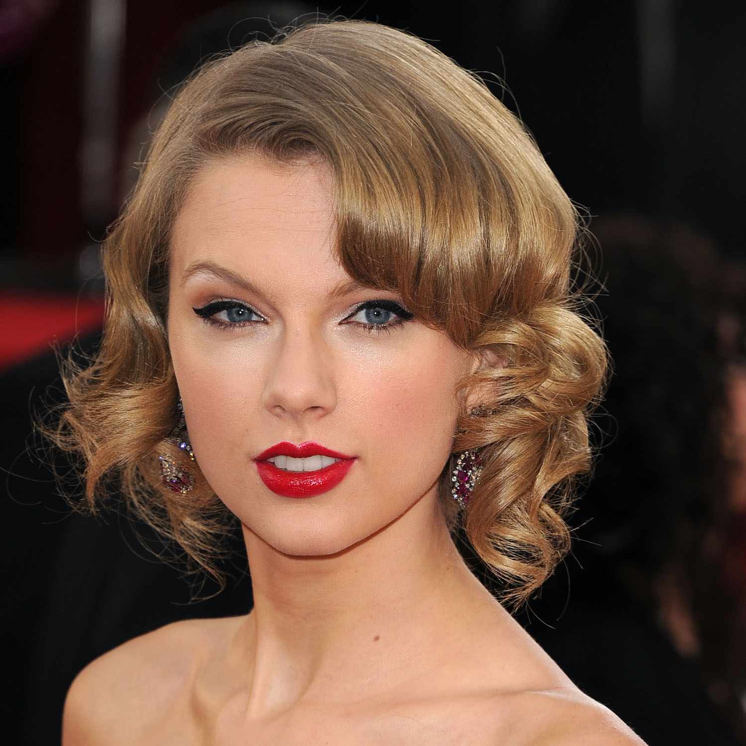 Taylor Swift em um bob encaracolado e batom vermelho
