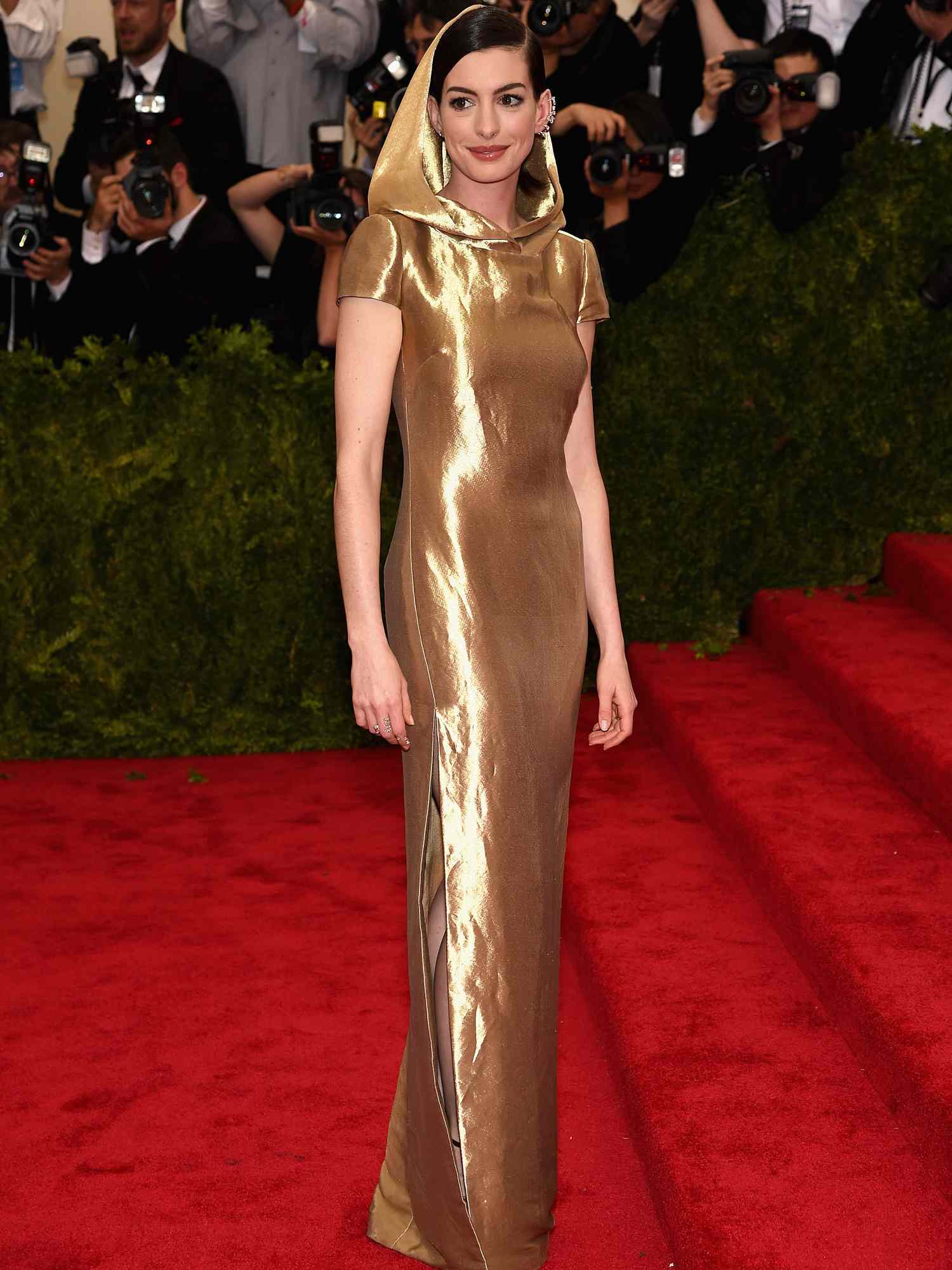 Anne Hathaway em um vestido de ouro com um capuz de Ralph Lauren no Met Gala 2015