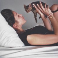 A autora de Byrdie, Tanya Akim, segura um gatinho em seus braços
