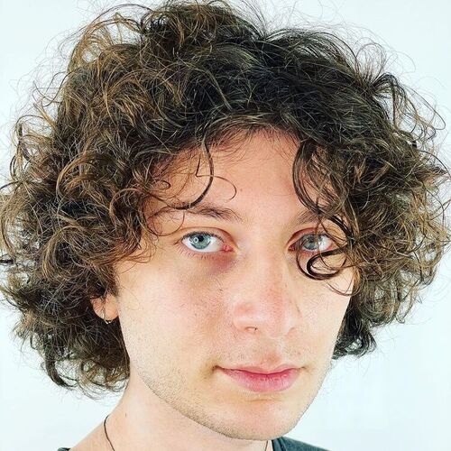 Penteados masculinos para cabelos ondulados - um homem com olhos azuis