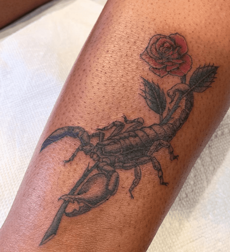 Escorpião com uma tatuagem de rosa em seu braço
