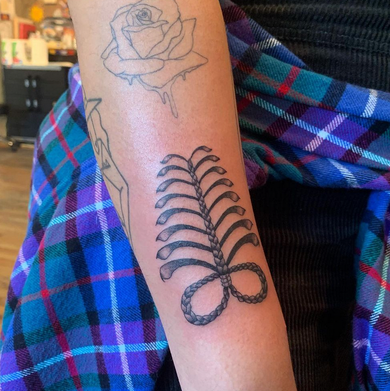Tatuagem de rosa derretida no braço