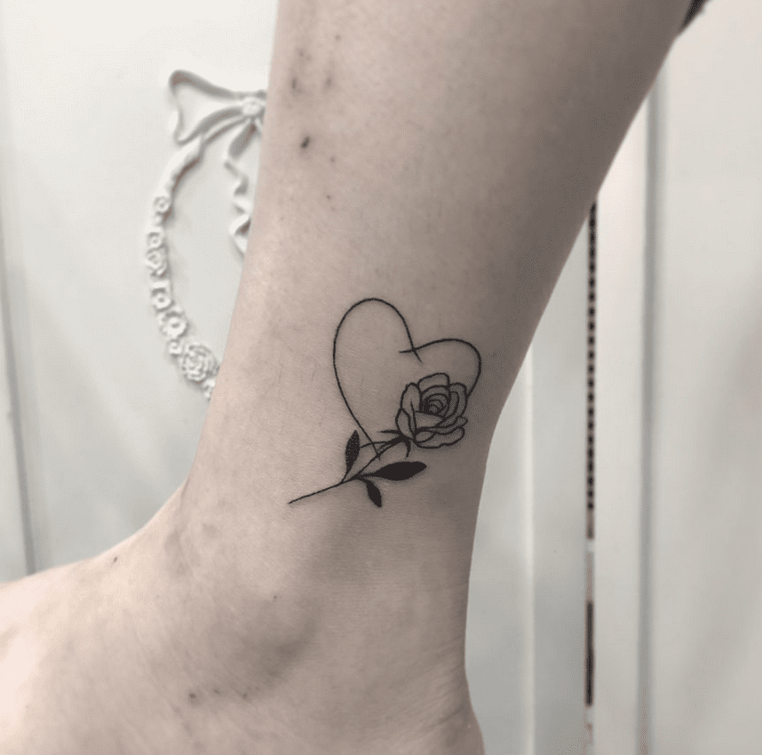 Tatuagem Rosa em um tornozelo com uma moldura de coração