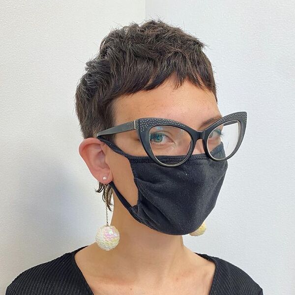 Corte de cabelo curto Pixie - uma mulher com óculos e uma máscara preta