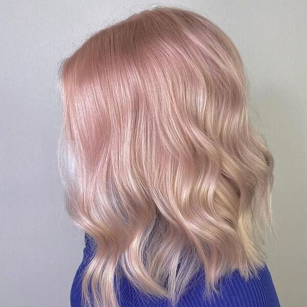 uma mulher de manga comprida azul tem um delicado penteado rosa pastel