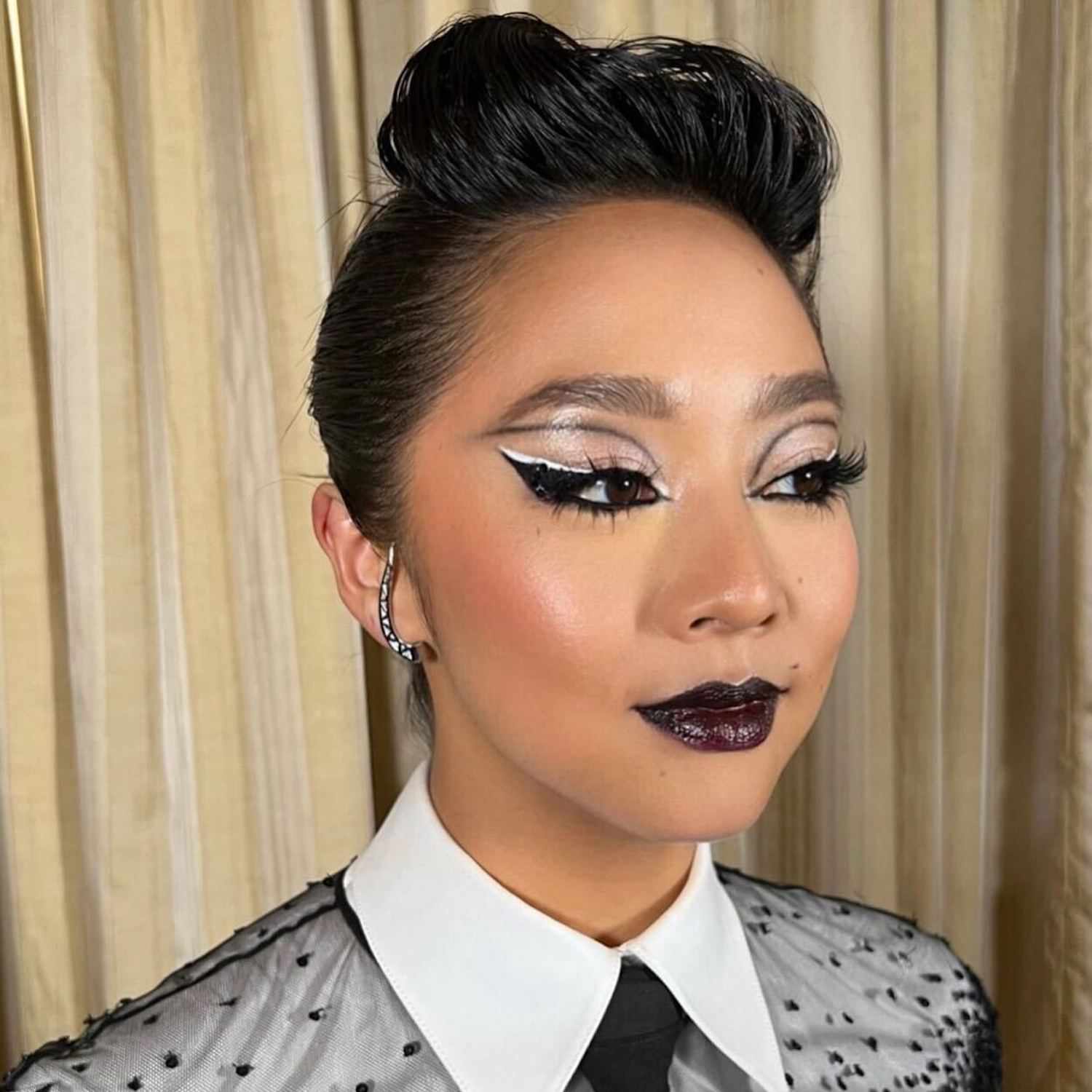 Stephanie Hsu com maquiagem dramática em preto e branco e lábios de geléia escura