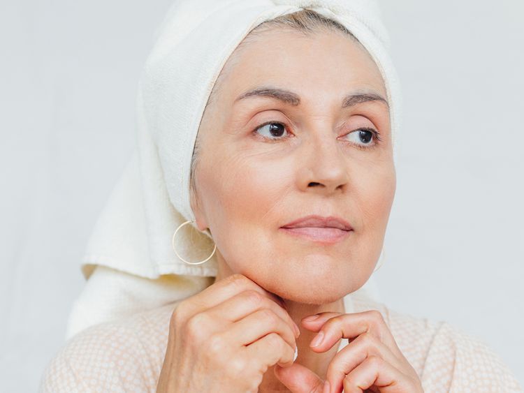 Close de uma mulher de 60 anos com uma toalha na cabeça