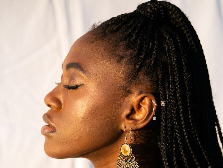 Vista em um perfil no rosto de uma mulher, demonstrando a textura natural da pele à luz do sol