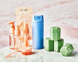 Vários frascos de produtos de higiene pessoal exibidos numa superfície de mármore
