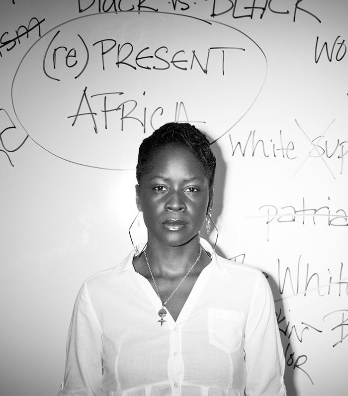 Uma mulher está em frente a um quadro branco com palavras escritas nele