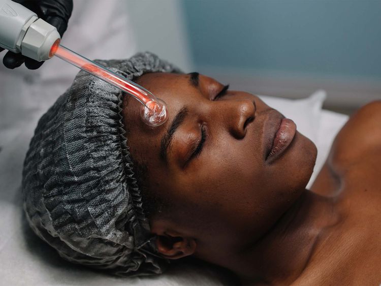 Uma mulher passa por tratamento a laser no rosto.